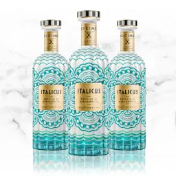 Three Italicus Rosolio di Bergamotto Decimo X anniversary edition bottles with turquoise patterns on white marble.
